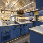 Elegant Molteni kitchen with blue appliances and yellow and blue tiles on the walls